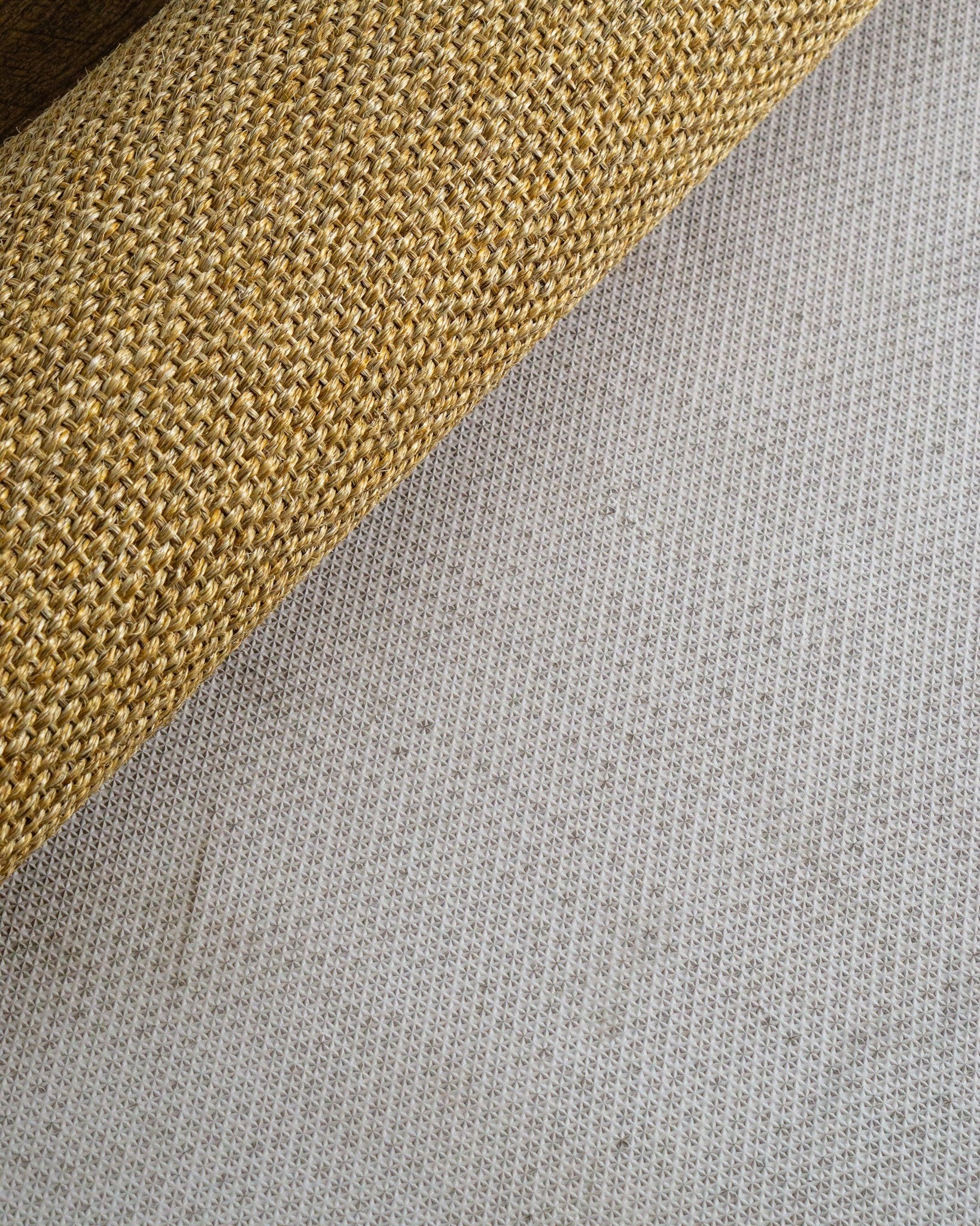 Natural woven jute rug with tight basket weave texture in tan and beige