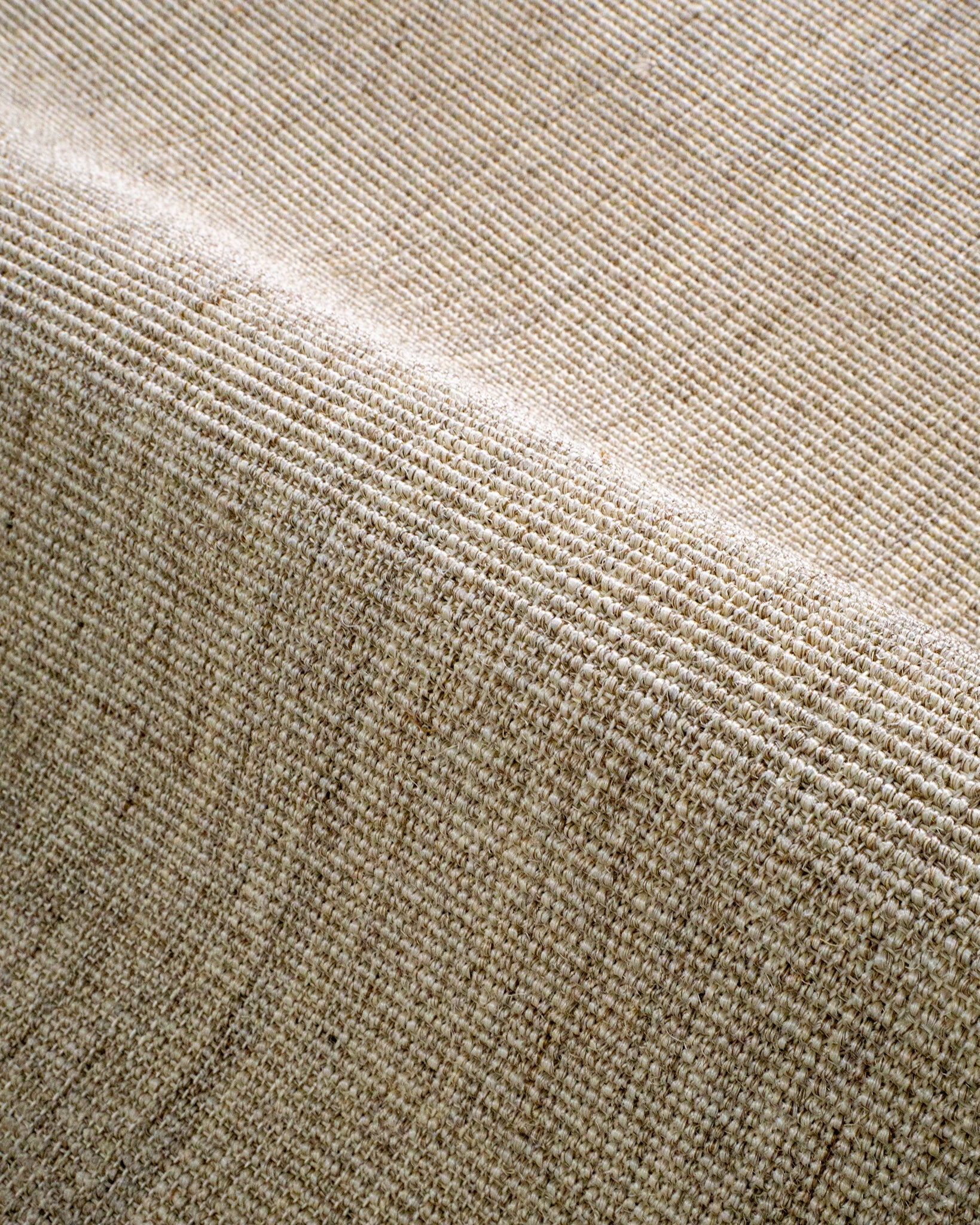 Natural woven texture rug with neutral tan and beige tones in flat weave style