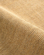 Natural woven jute rug with tight ribbed texture in golden tan color