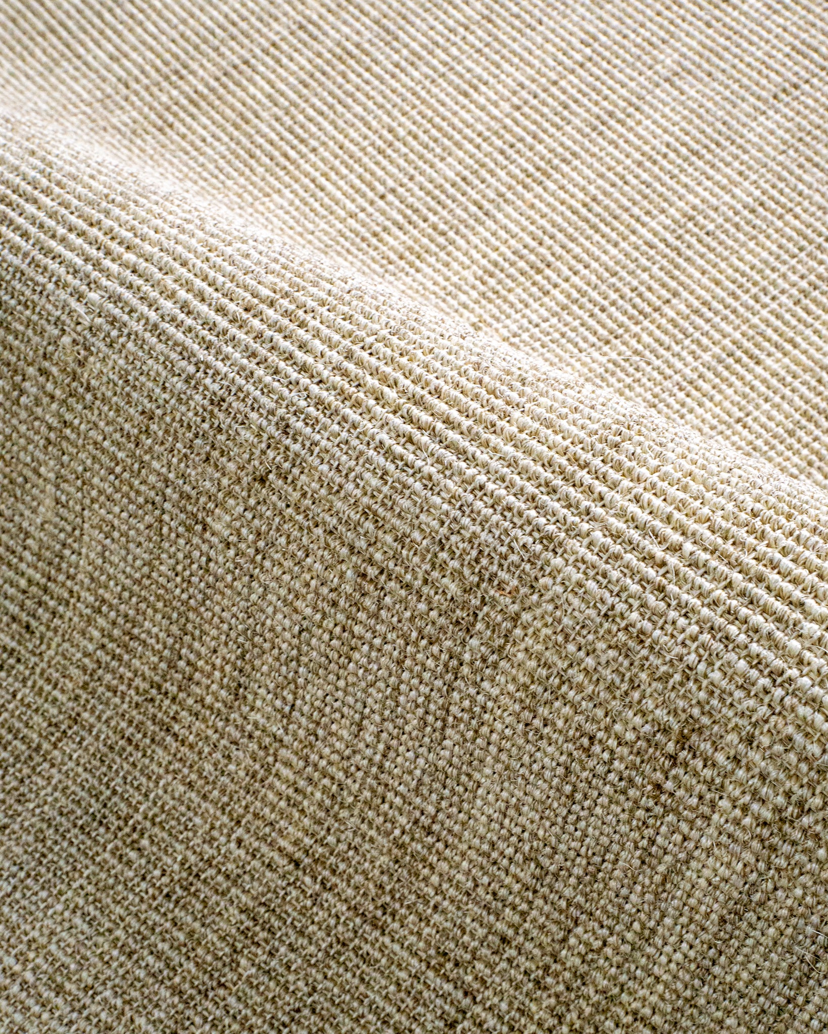Neutral beige textured woven rug with ribbed pattern in natural fibers