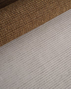 Woven natural fiber rug with tan and brown textured striped pattern