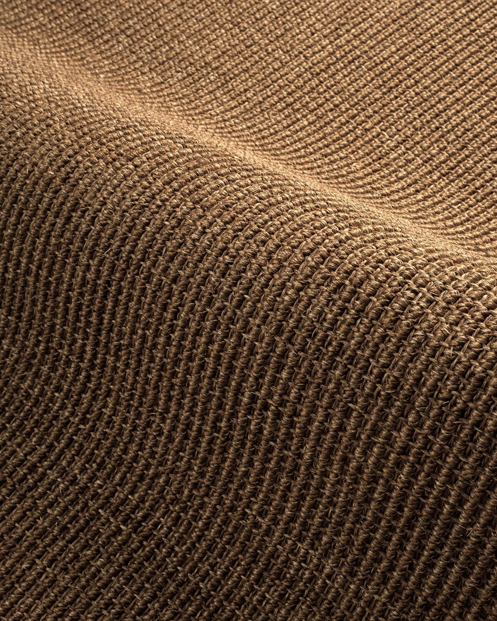 Woven natural fiber rug with tan and brown textured striped pattern