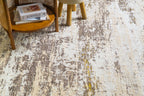 Distressed beige and grey rug with abstract texture and worn vintage aesthetic
