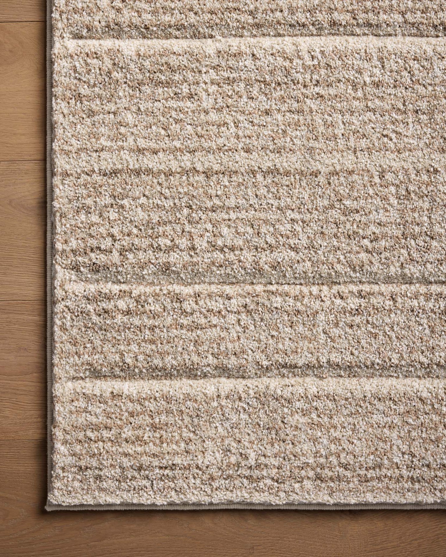 Beige textured area rug with horizontal woven pattern in neutral tones