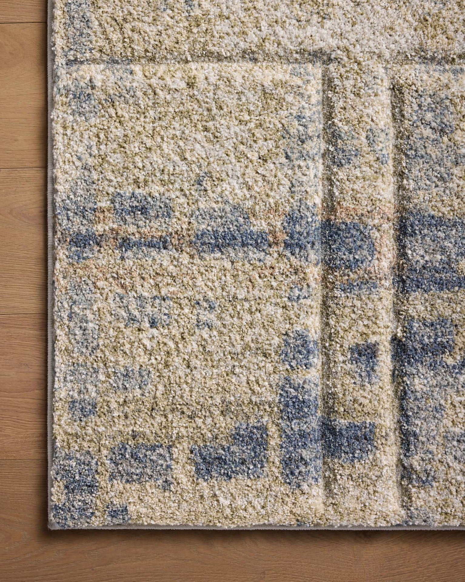 Beige and blue abstract geometric patterned rug with textured wool surface