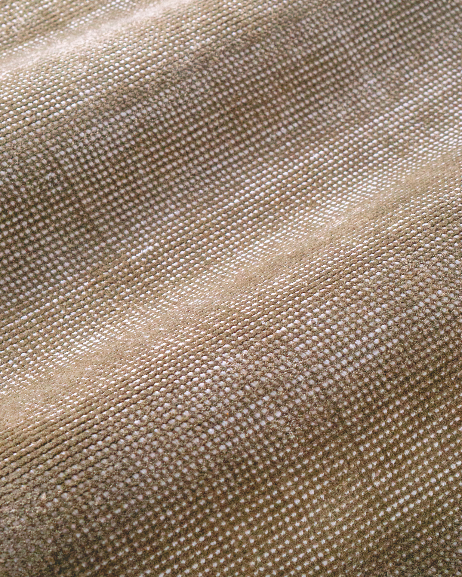Beige textured rug with subtle horizontal striations and soft woven finish