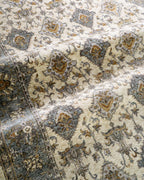 Cream and blue traditional rug with geometric diamond patterns and ornate border