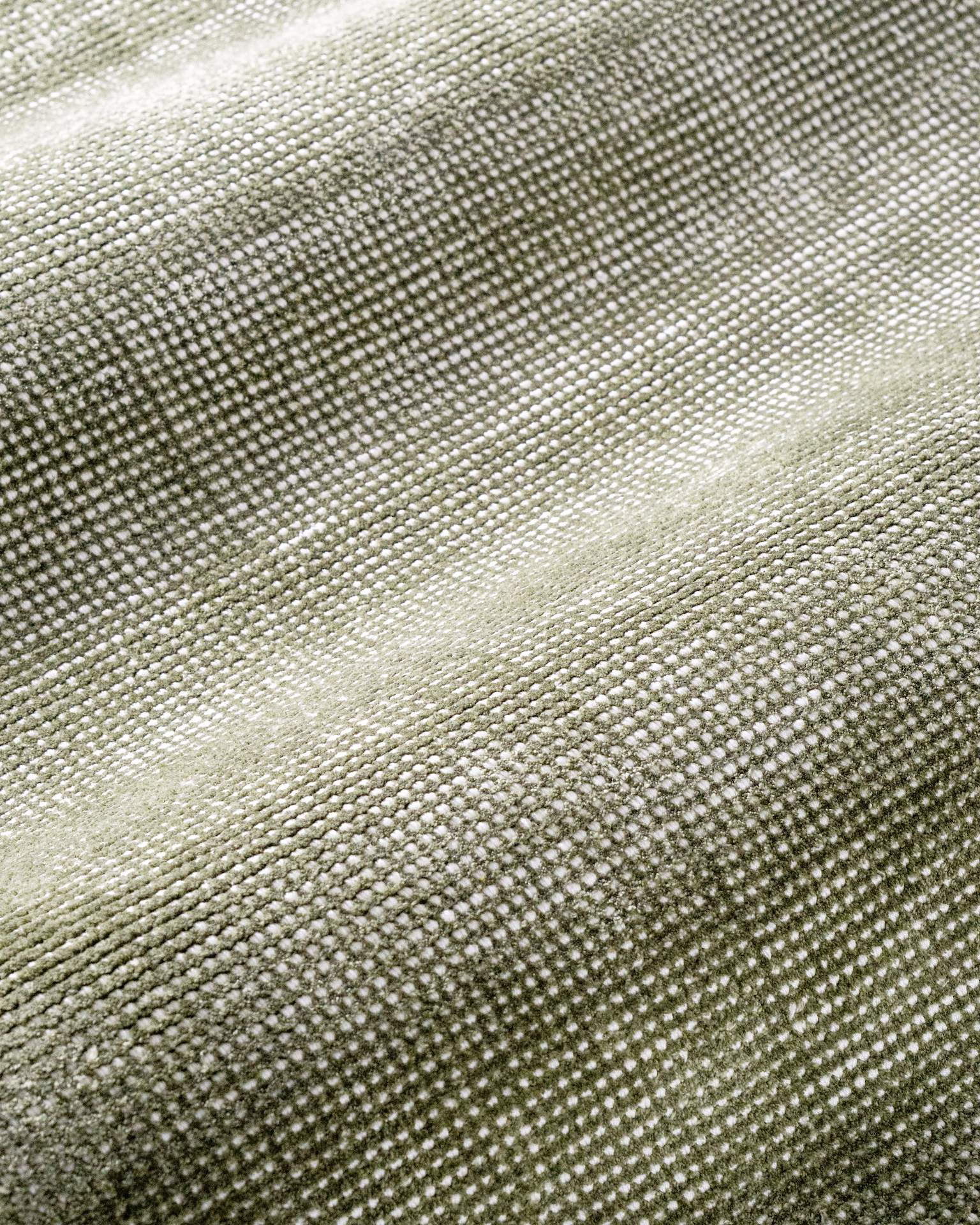 Sage green textured velvet rug with subtle worn vintage distressing throughout
