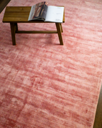 Amara viscose hand-loomed area rug in Coral Pink, styled in a living room