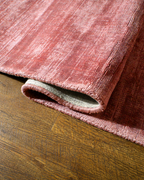 Amara viscose hand-loomed area rug in Coral Pink, curled edge detail