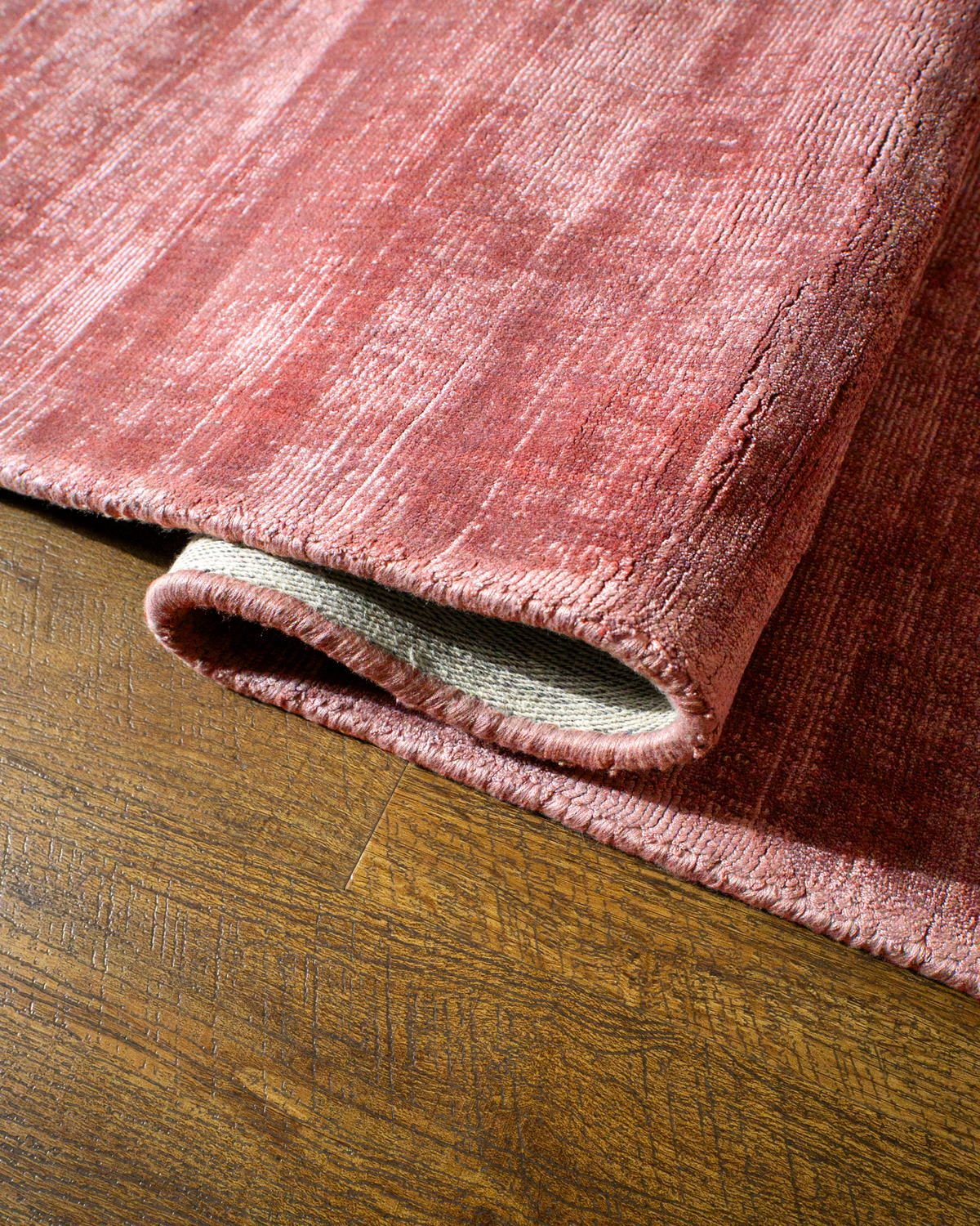 Amara viscose hand-loomed area rug in Coral Pink, curled edge detail