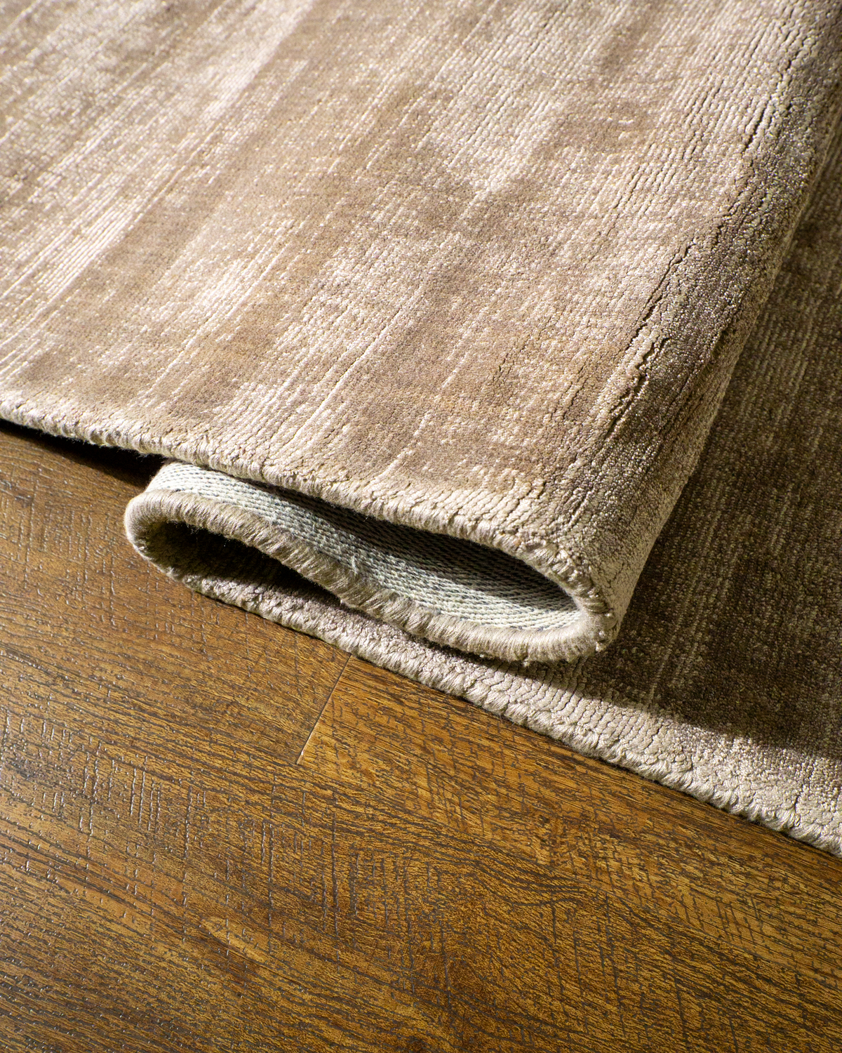 Amara viscose hand-loomed area rug in Dark Brown, curled edge detail