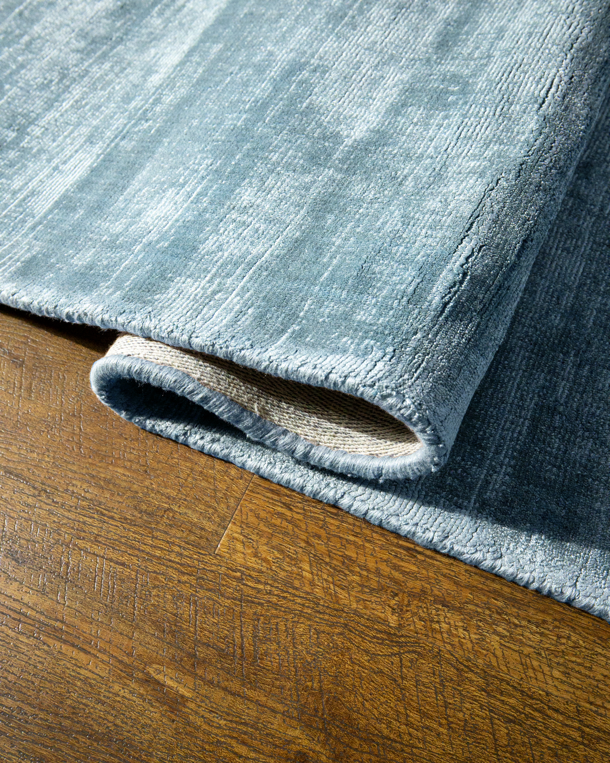 Amara viscose hand-loomed area rug in Dark Cyan, curled edge detail