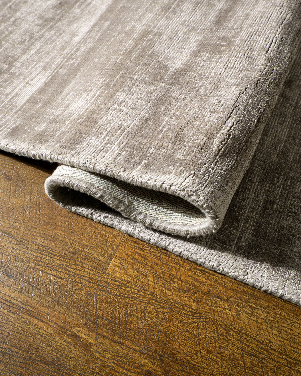 Amara viscose hand-loomed area rug in Dusk Grey, curled edge detail
