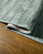Amara viscose hand-loomed area rug in Evergreen, curled edge detail