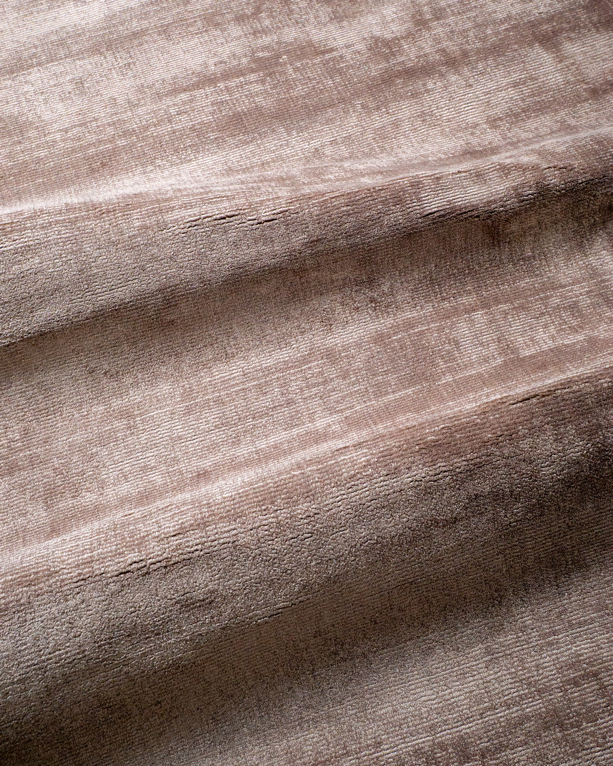 Amara viscose hand-loomed area rug in Light Mauve, draped to show the sheen