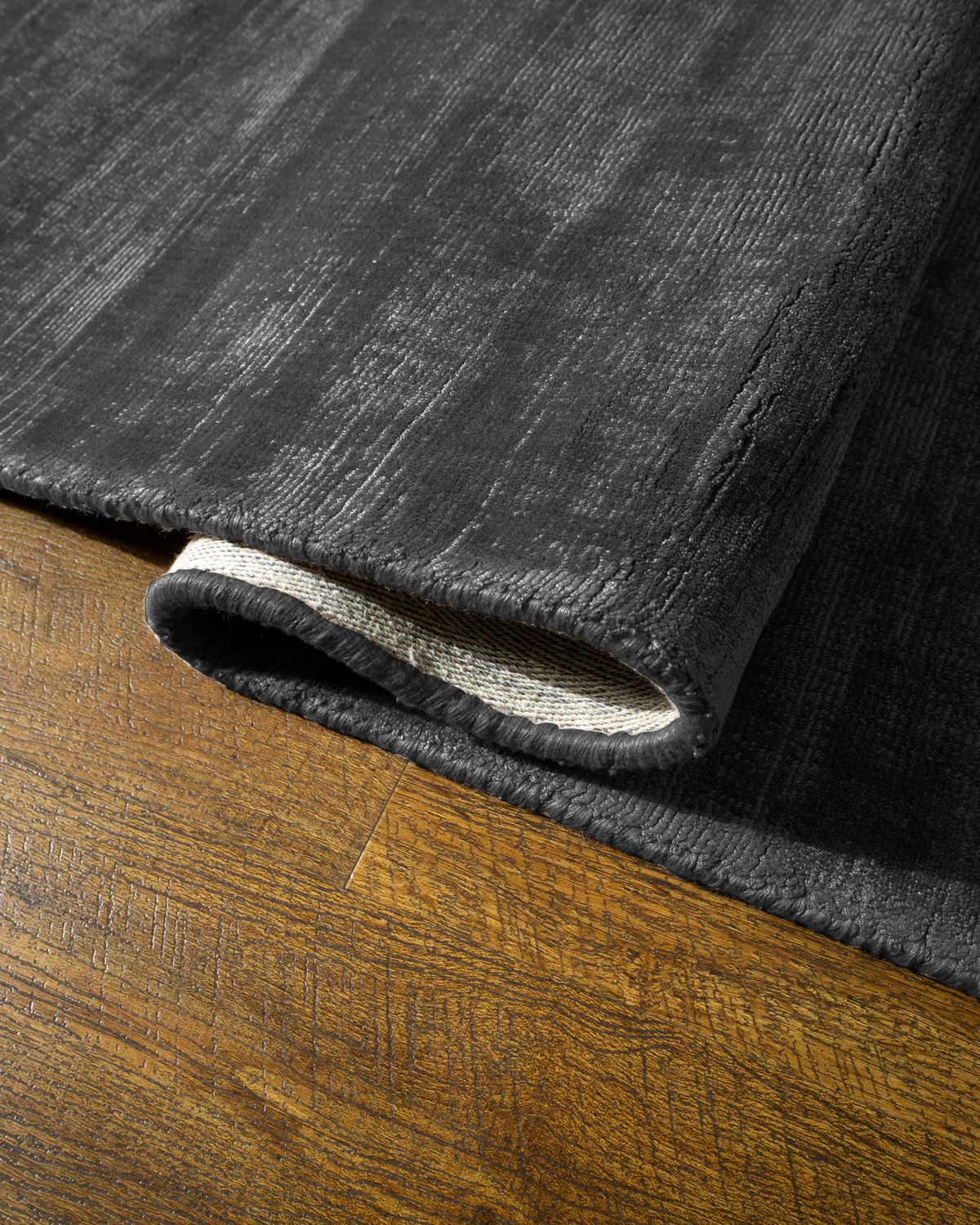Amara viscose hand-loomed area rug in Navy Black, curled edge detail