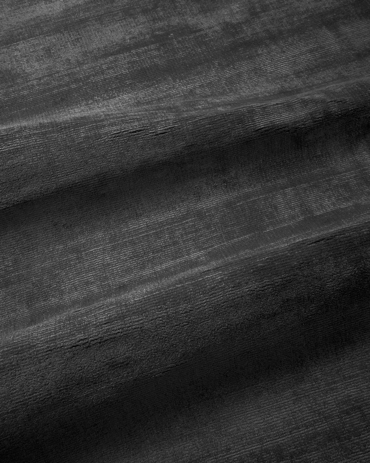 Amara viscose hand-loomed area rug in Navy Black, draped to show the sheen