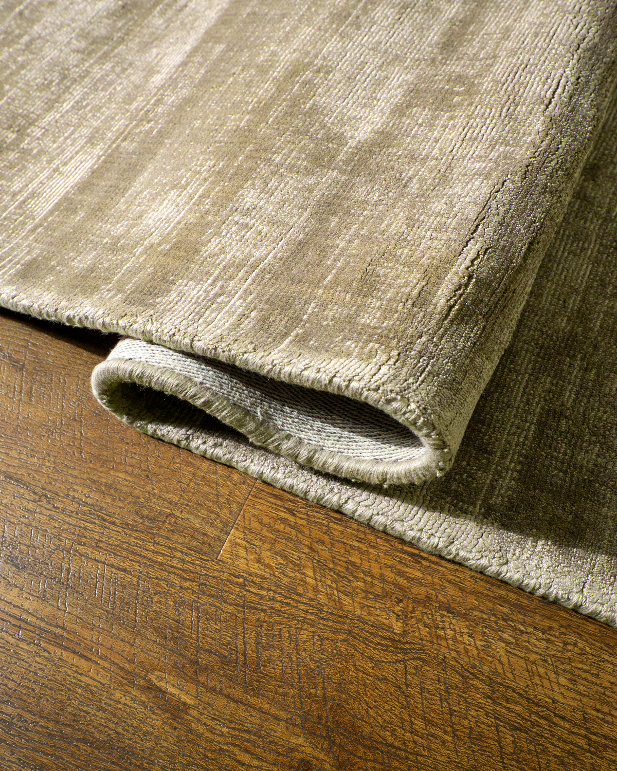 Amara viscose hand-loomed area rug in Olive Brown, curled edge detail