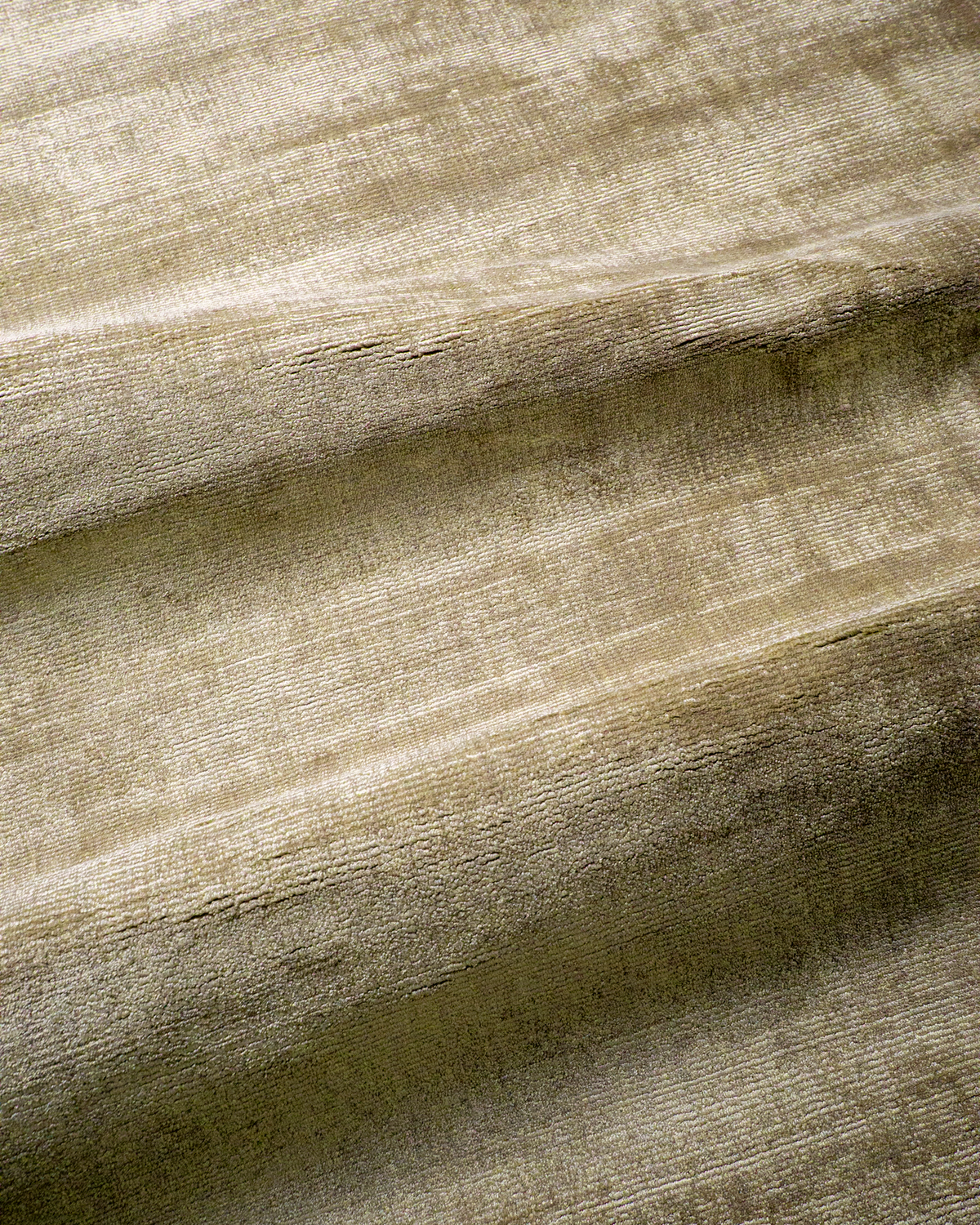 Amara viscose hand-loomed area rug in Olive Brown, draped to show the sheen