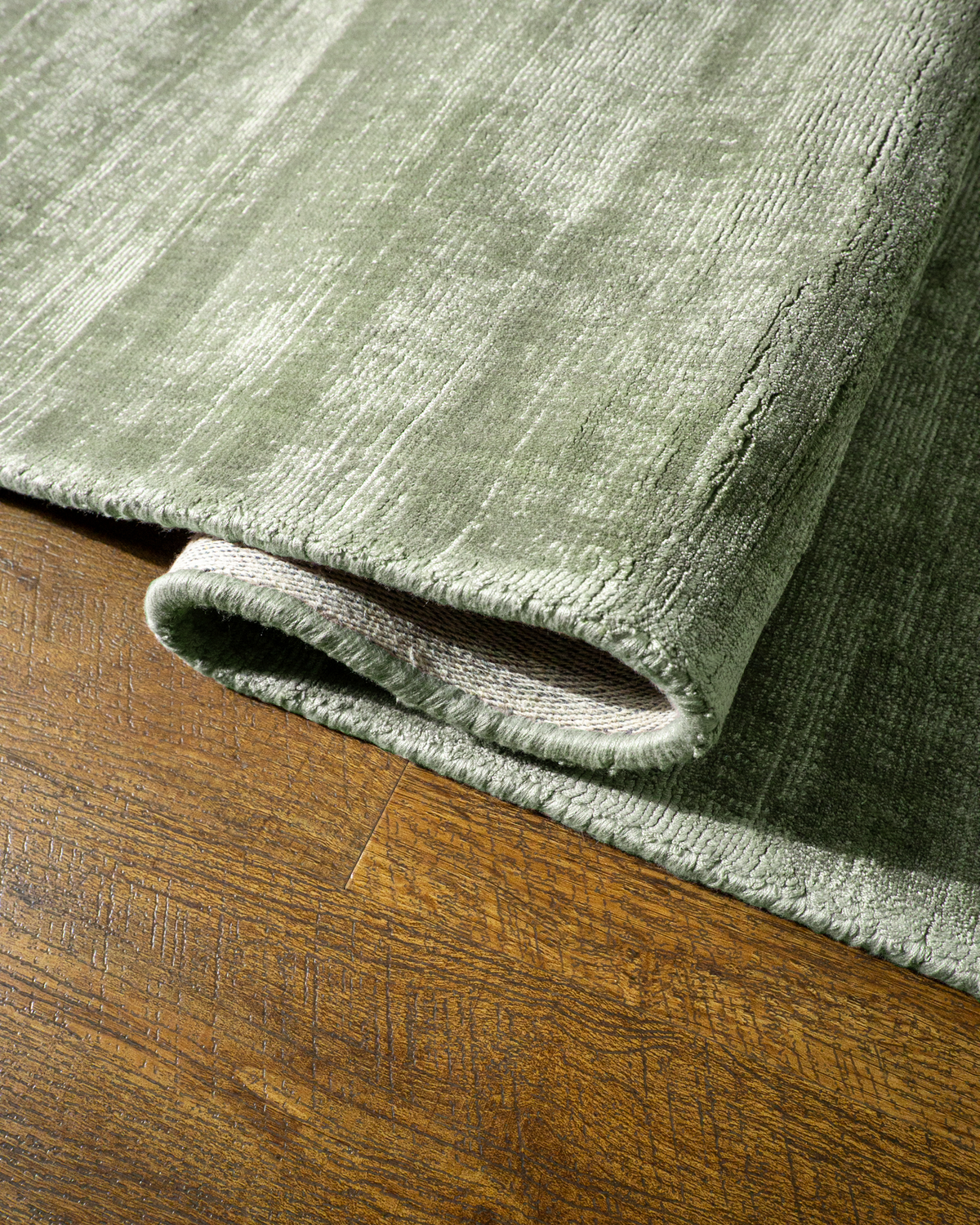 Amara viscose hand-loomed area rug in Sage, curled edge detail