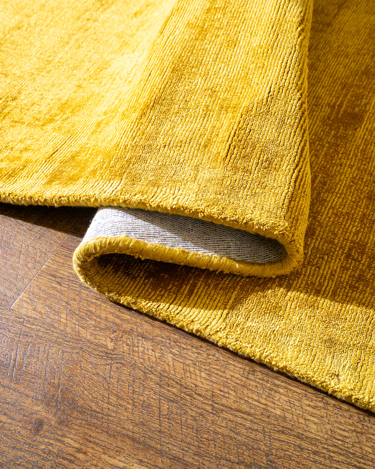 Amara viscose hand-loomed area rug in Yellow, curled edge detail