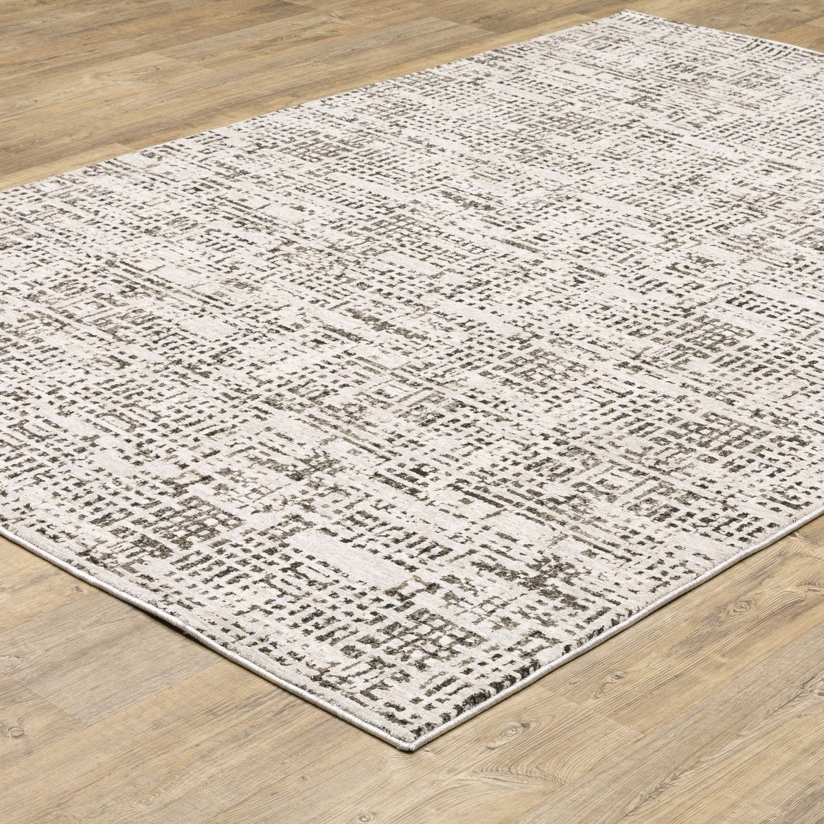 Modern geometric patterned rug in cream and brown tones on wood flooring