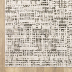 Modern geometric patterned rug in cream and brown tones on wood flooring