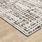 Modern geometric patterned rug in cream and brown tones on wood flooring