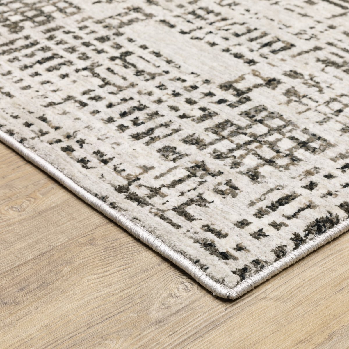 Modern geometric patterned rug in cream and brown tones on wood flooring
