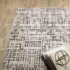 Modern geometric patterned rug in cream and brown tones on wood flooring