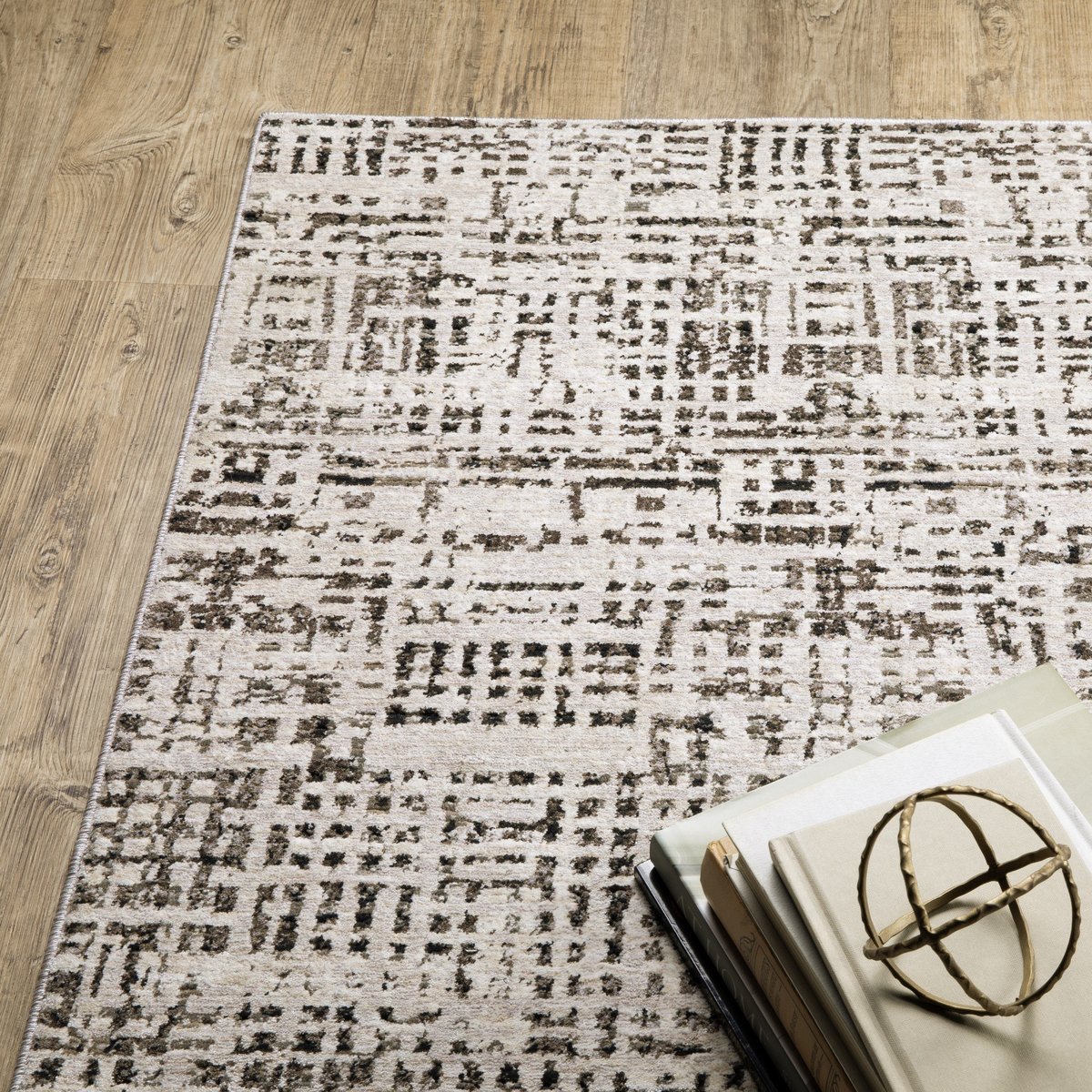 Modern geometric patterned rug in cream and brown tones on wood flooring