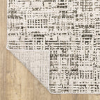 Modern geometric patterned rug in cream and brown tones on wood flooring