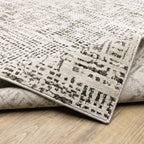 Modern geometric patterned rug in cream and brown tones on wood flooring