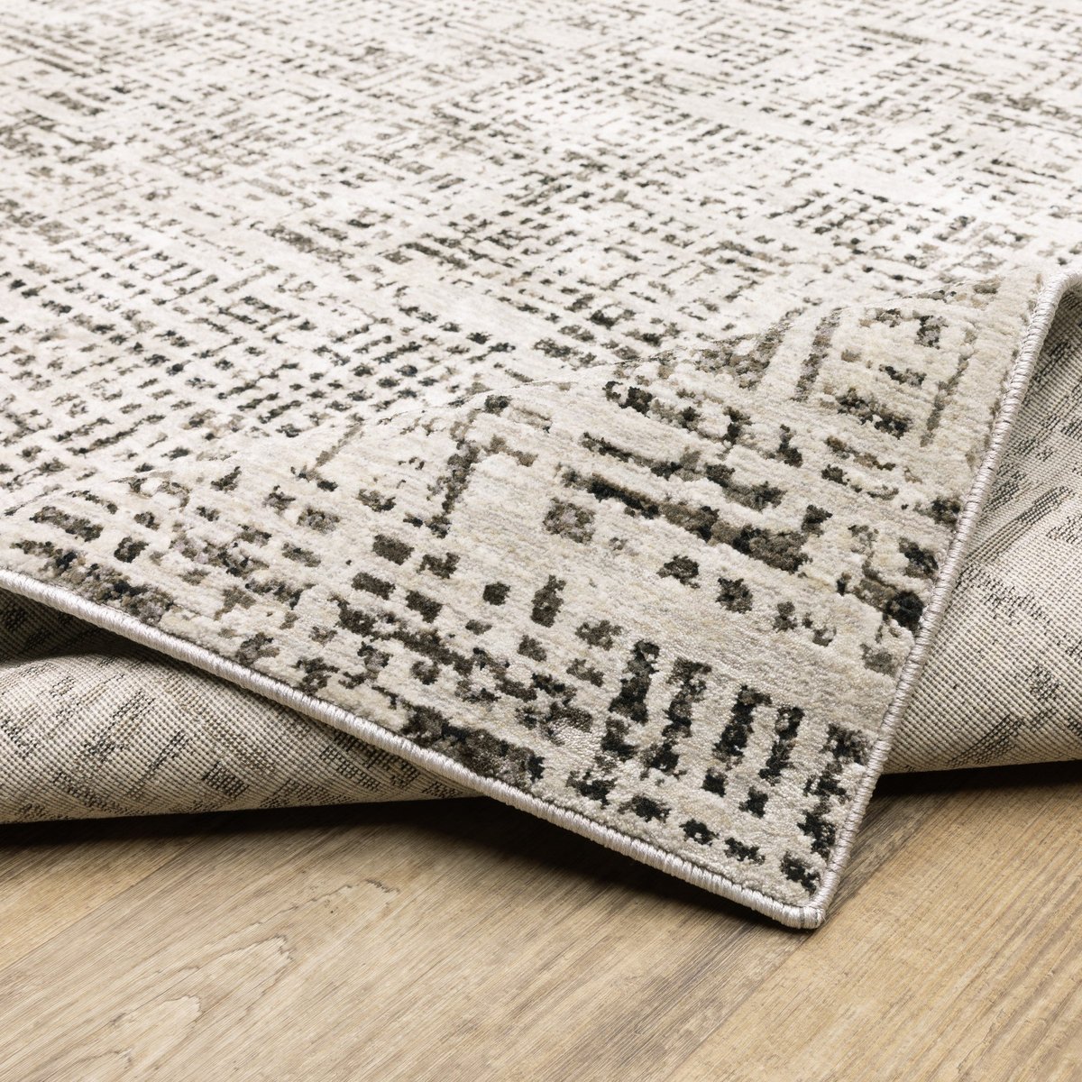 Modern geometric patterned rug in cream and brown tones on wood flooring