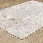 Distressed beige and grey textured rug with mottled vintage appearance