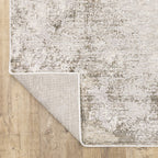 Distressed beige and grey textured rug with mottled vintage appearance