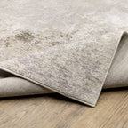Distressed beige and grey textured rug with mottled vintage appearance