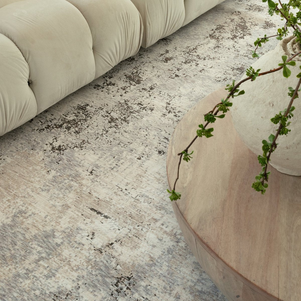 Distressed beige and grey textured rug with mottled vintage appearance
