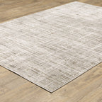 Beige textured area rug with abstract grid pattern on light wood flooring