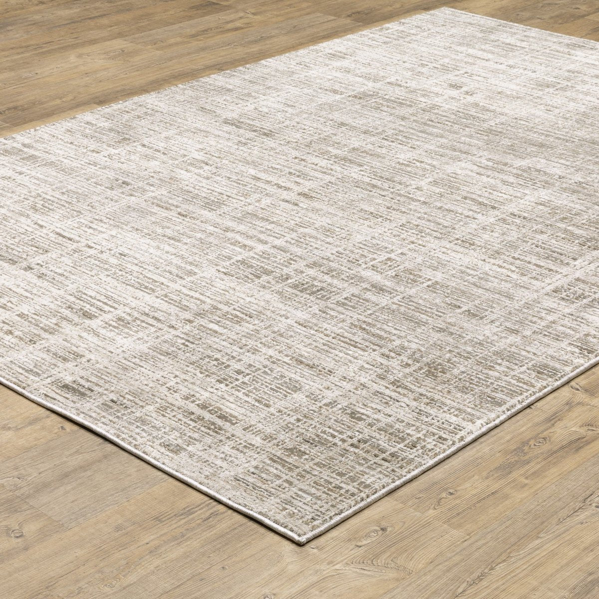 Beige textured area rug with abstract grid pattern on light wood flooring