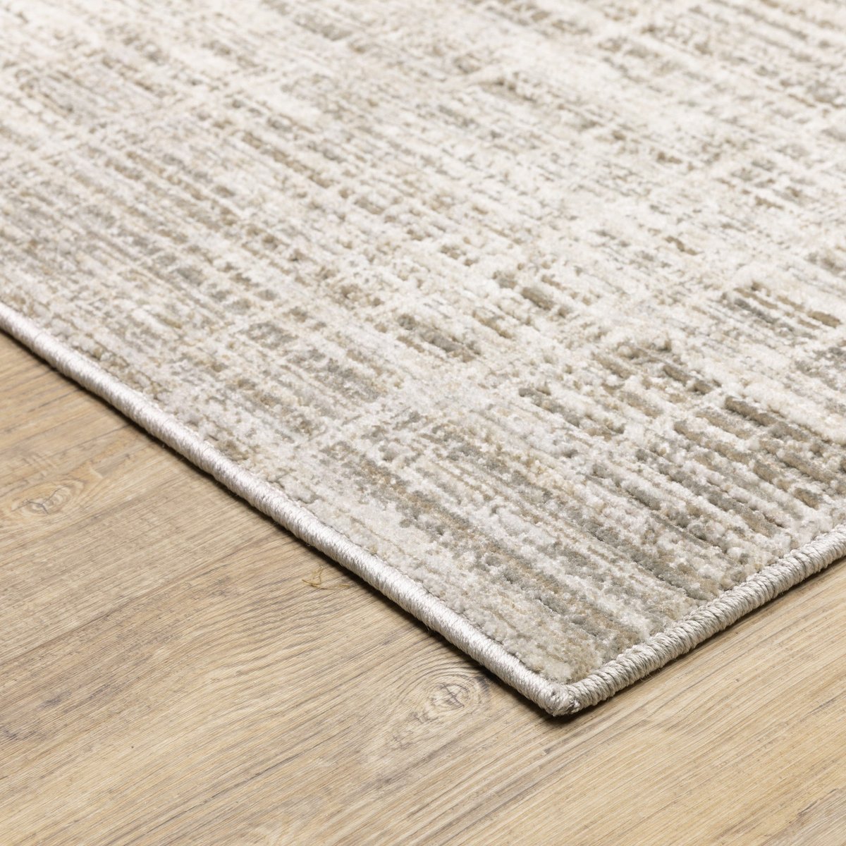 Beige textured area rug with abstract grid pattern on light wood flooring