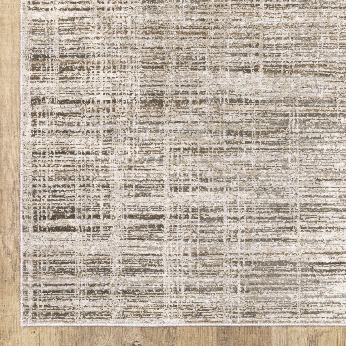 Beige textured area rug with abstract grid pattern on light wood flooring