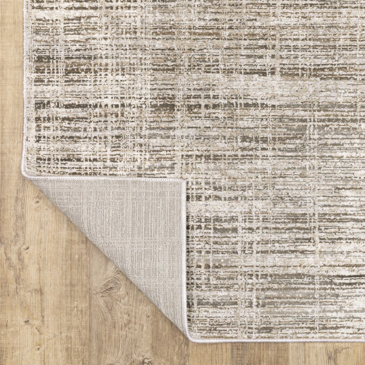 Beige textured area rug with abstract grid pattern on light wood flooring