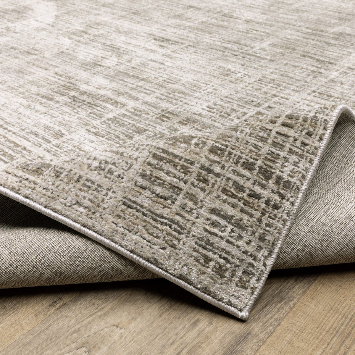 Beige textured area rug with abstract grid pattern on light wood flooring