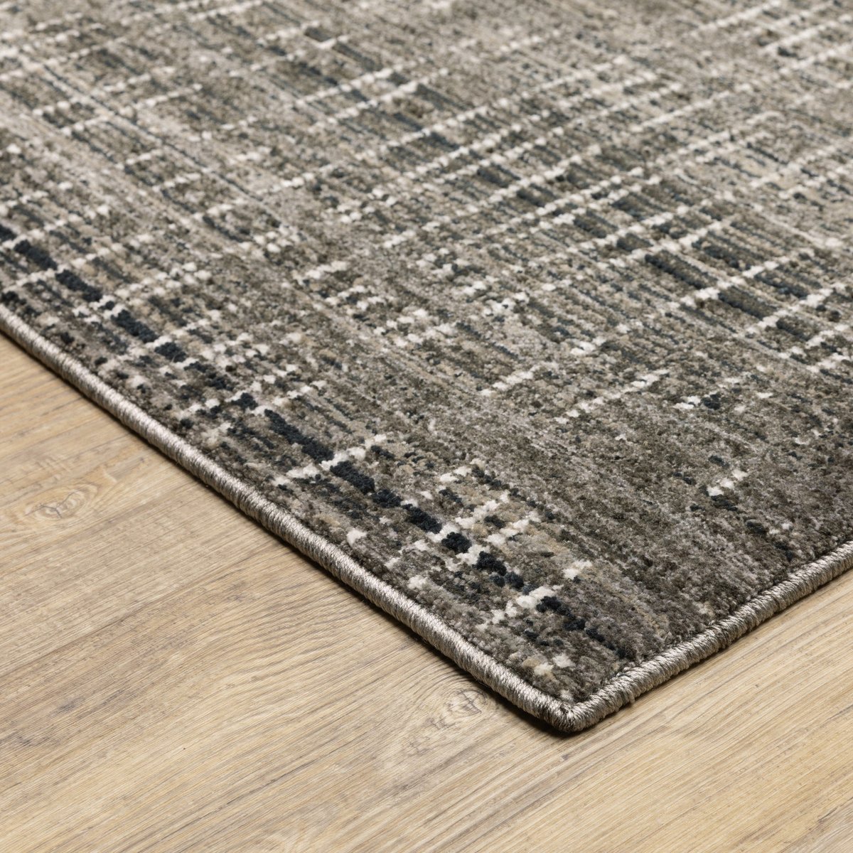 Gray textured area rug with white linear crosshatch pattern throughout