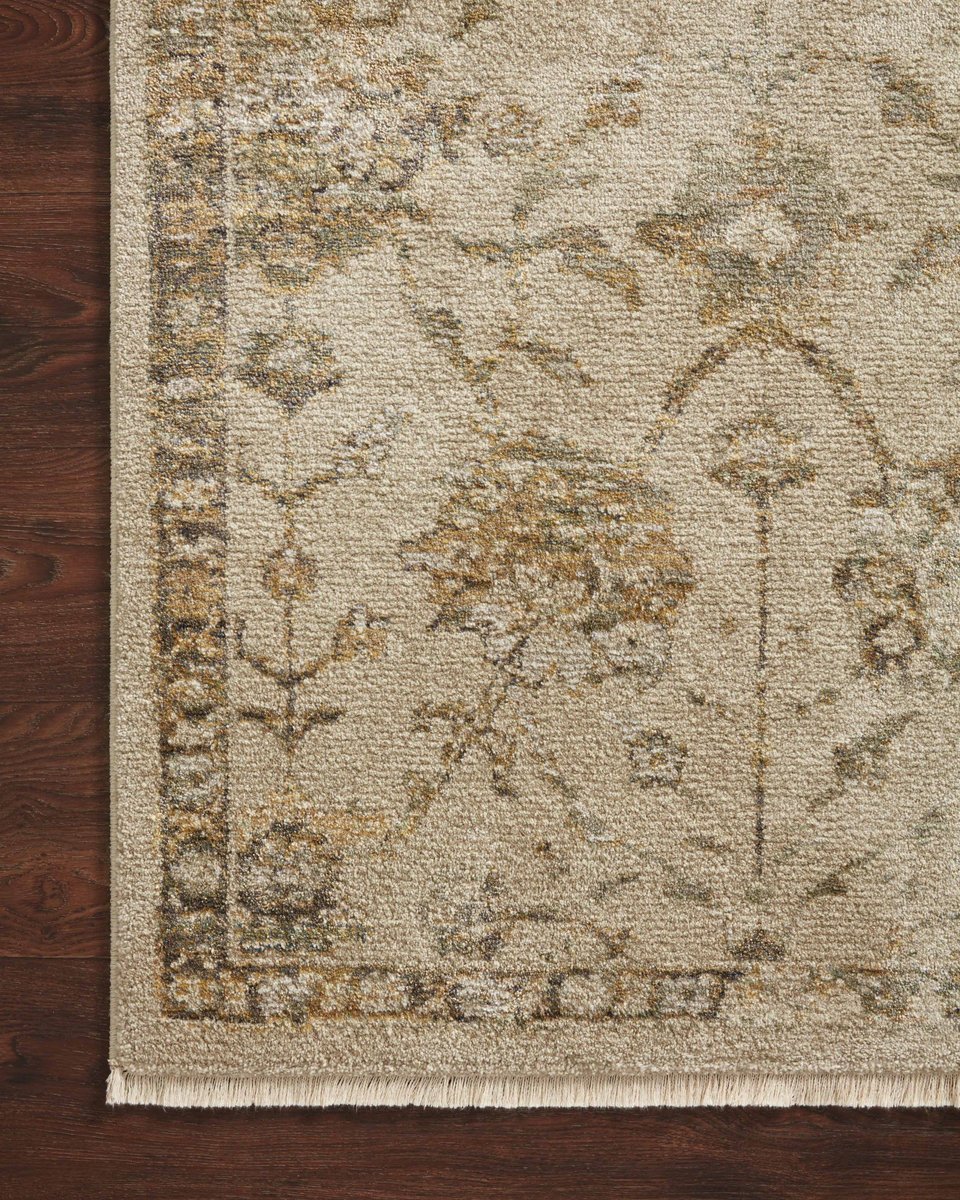 Beige and tan distressed floral pattern rug on dark wood flooring