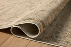 Beige and tan distressed floral pattern rug on dark wood flooring