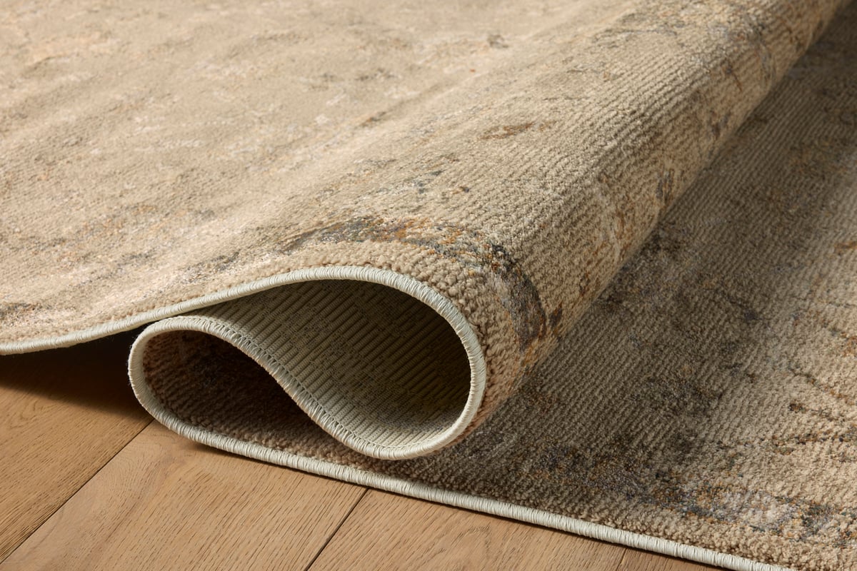 Beige and tan distressed floral pattern rug on dark wood flooring