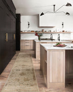 Beige and tan distressed floral pattern rug on dark wood flooring